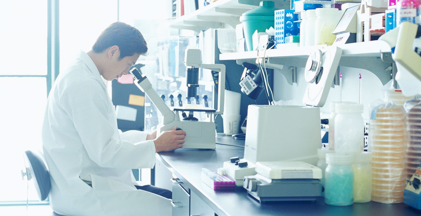 A Millar oncology doctor looks through a microscope