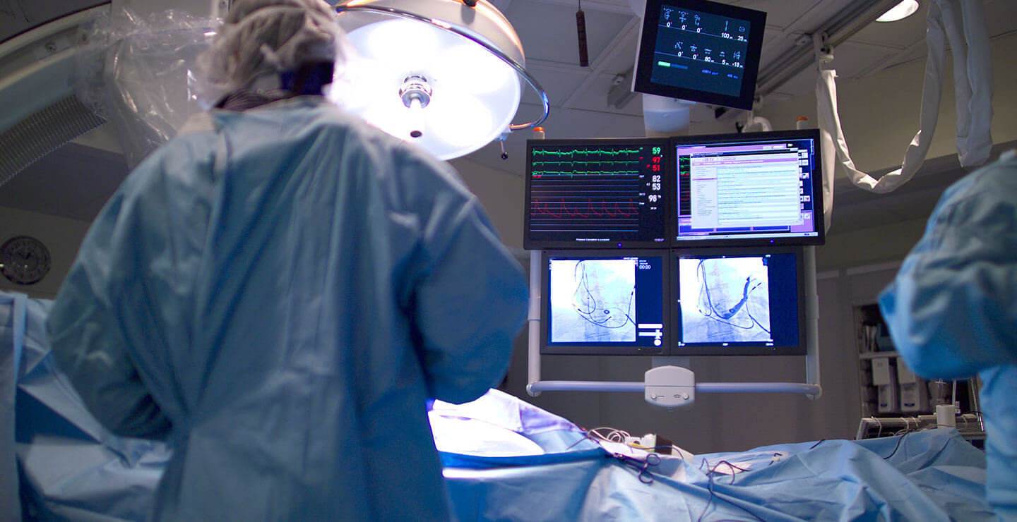 Doctors operate on a patient with monitors feeding them data from Millar catheters